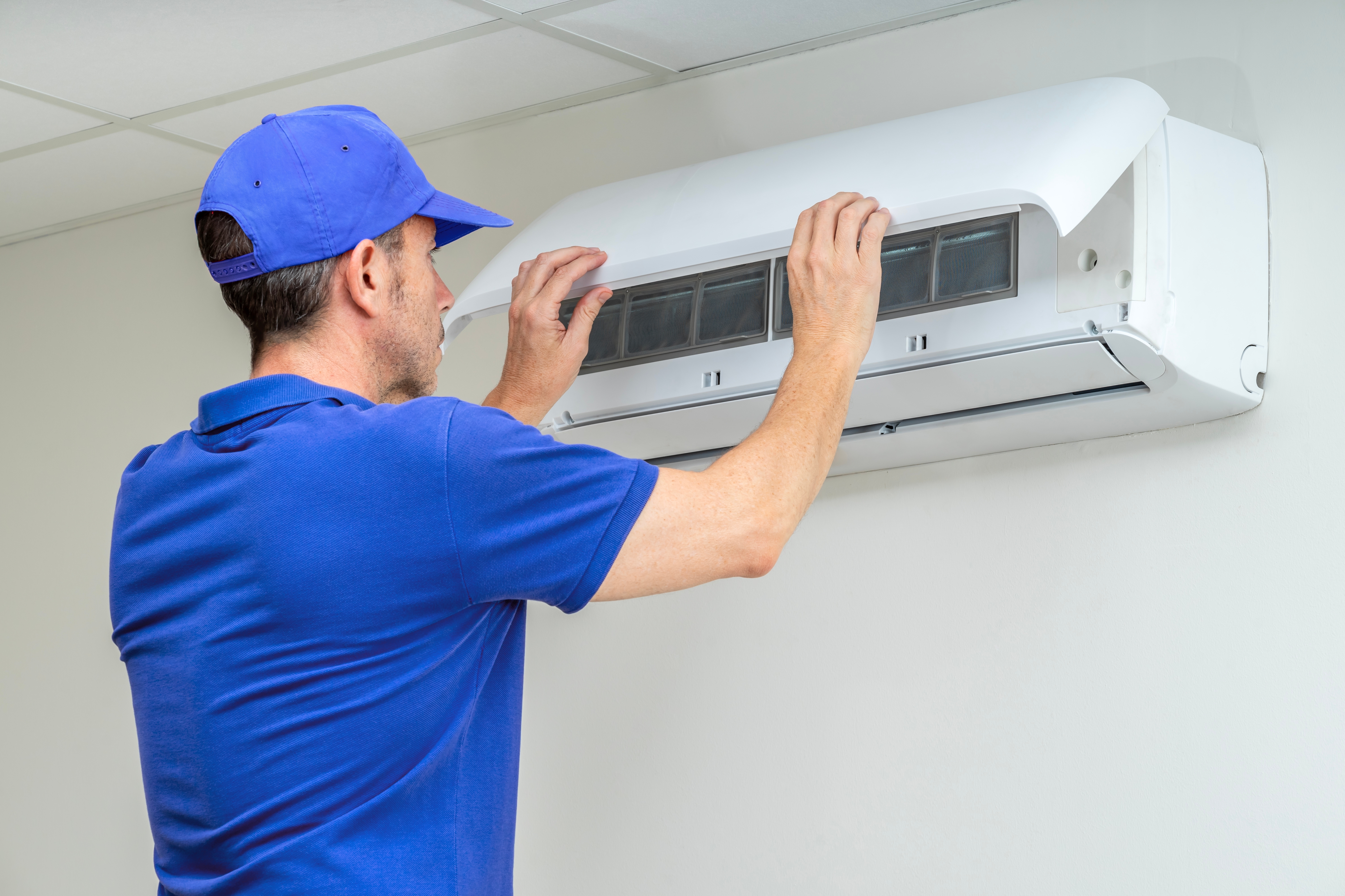 Hvac technician performing air conditioner maintenance inspection at acme house company vacation ren4tal